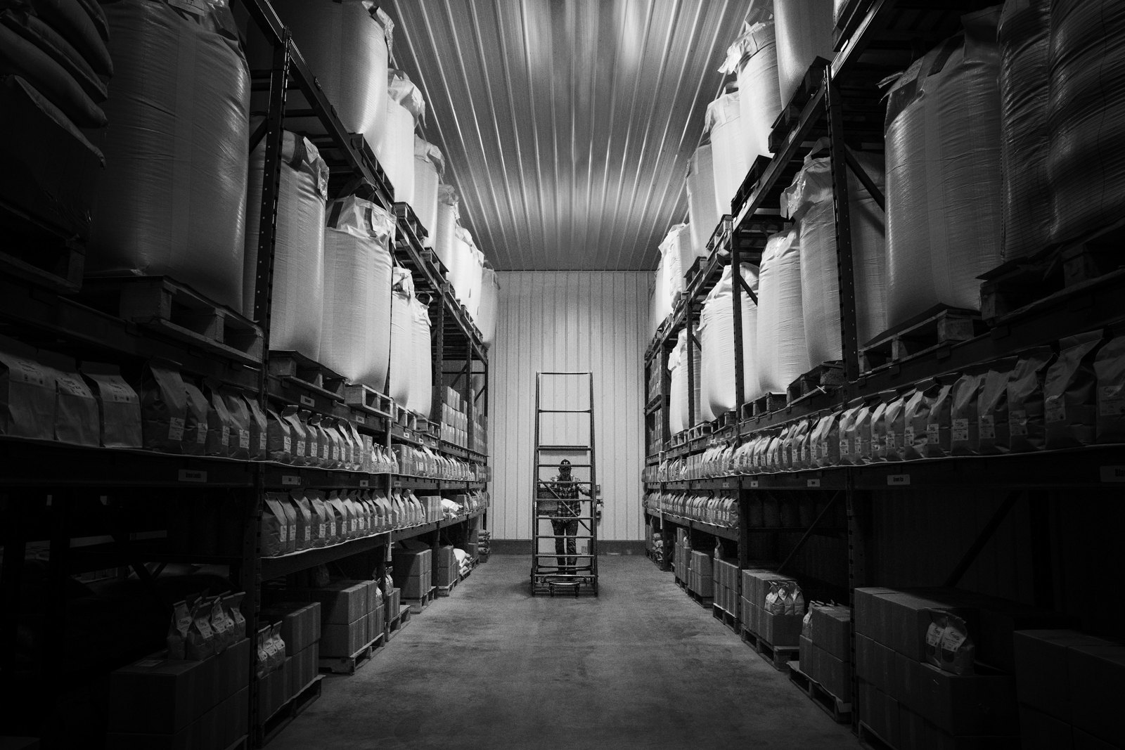 Aisle of a warehouse stacked with bulk bags of plastic resin
