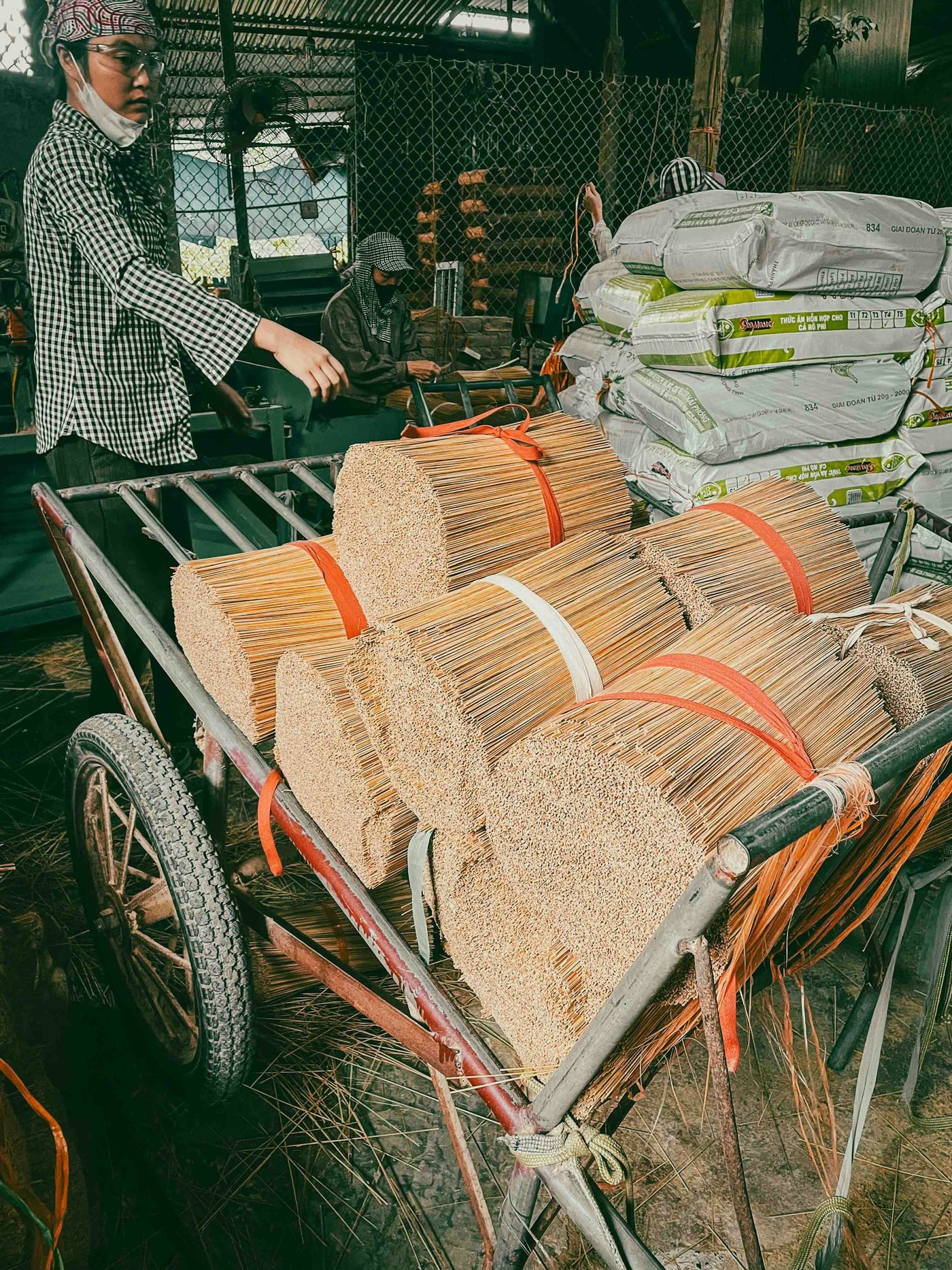 Bundles of raw incense sticks loaded on a cart for delivery
