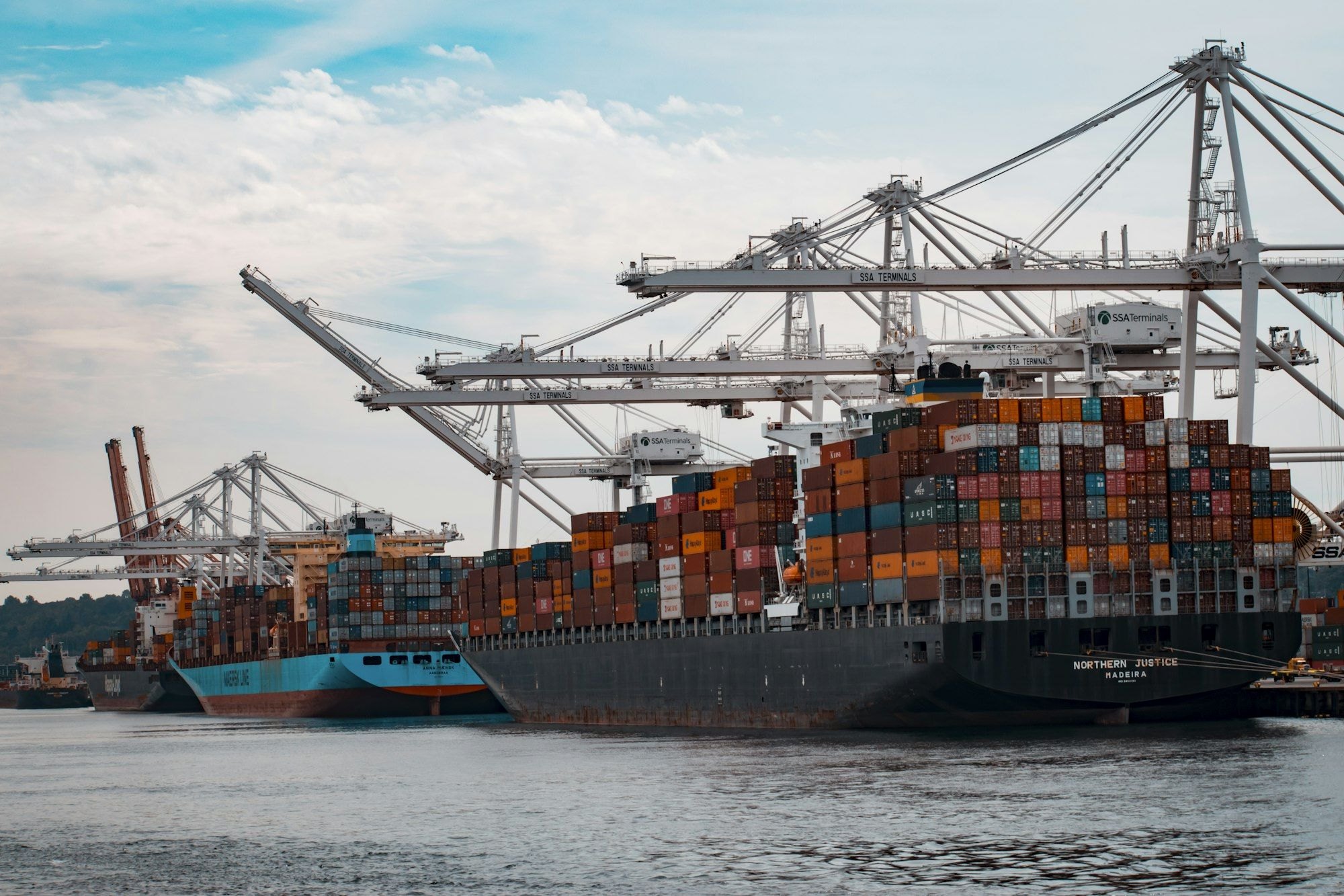 Container ship being loaded by cranes at a port