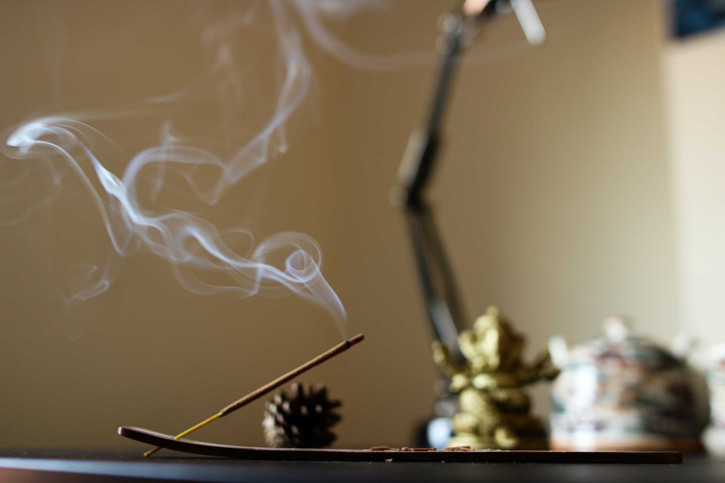Incense burning on a home altar beside a small Ganesha statue