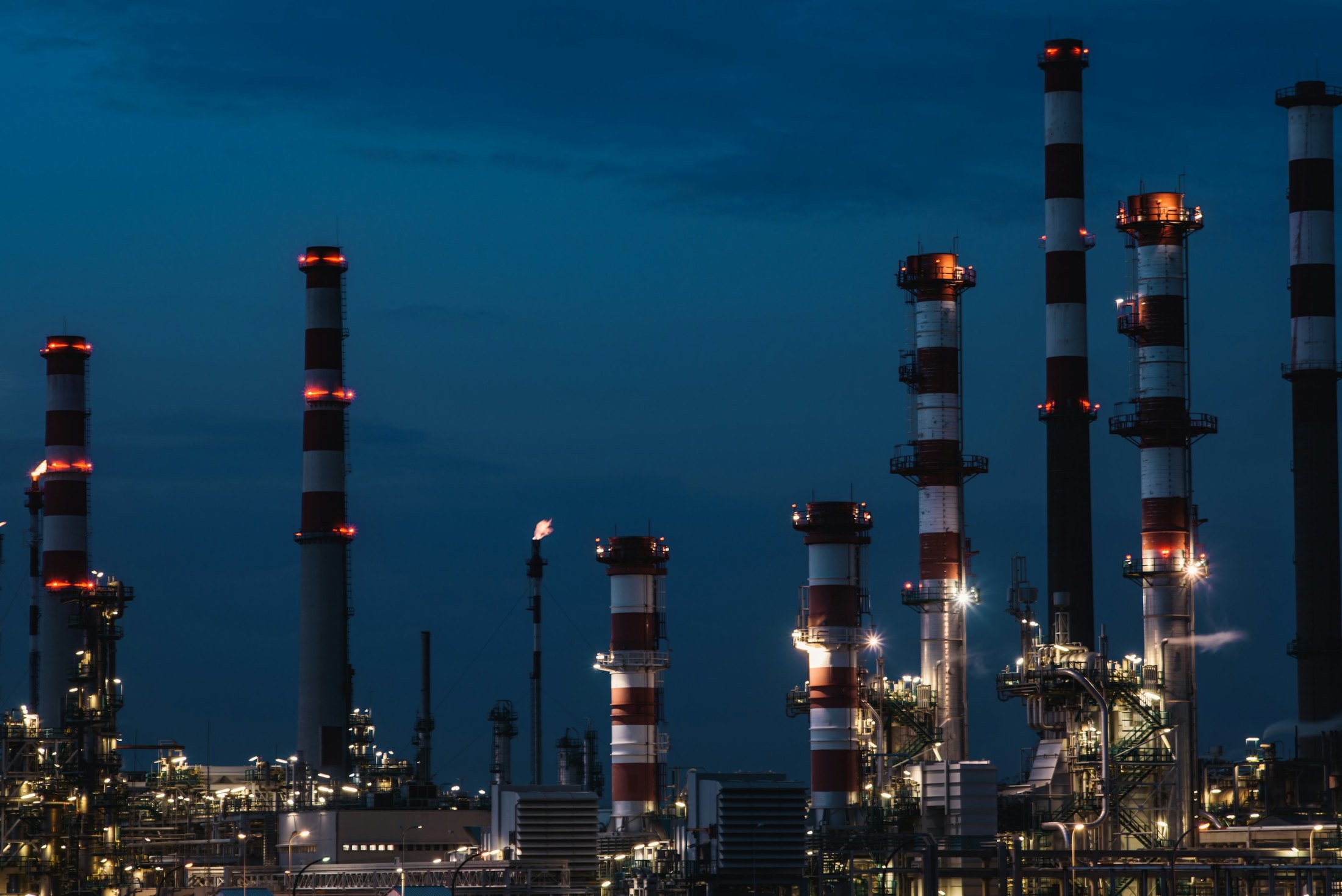 Petrochemical plant towers lit up at blue hour