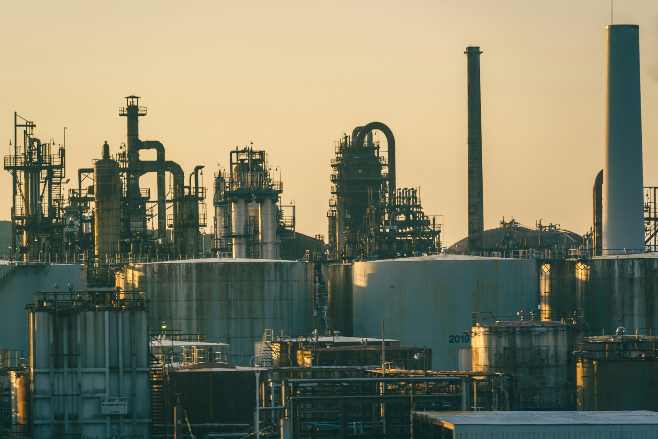 Refinery towers and storage tanks at golden hour