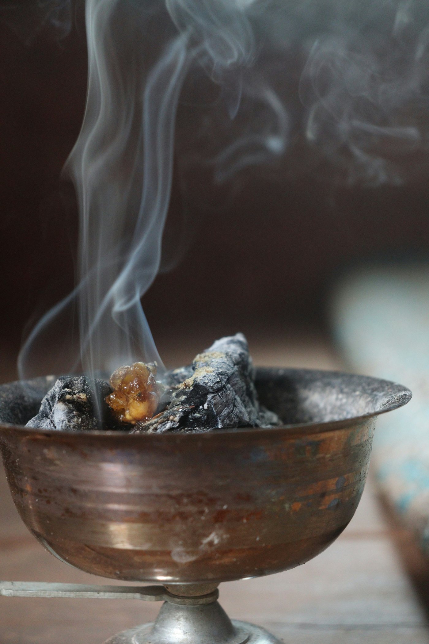 Resin smoldering on charcoal in a brass bowl