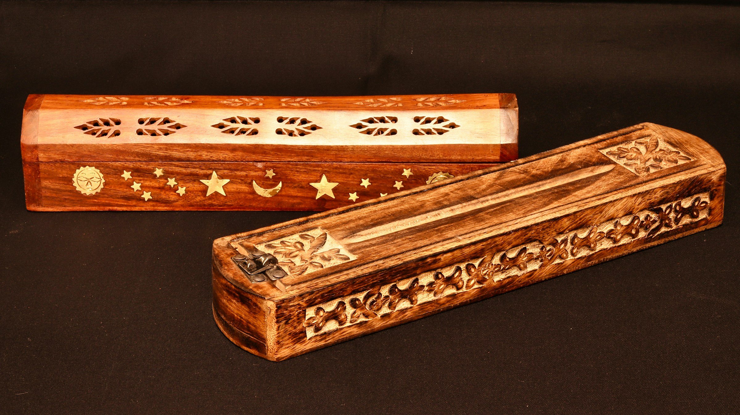 Two carved wooden incense boxes, one with brass sun, moon, and star inlays